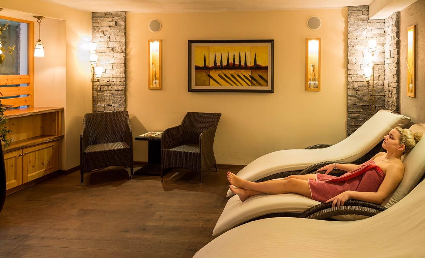 Ragazza sdraiata sui lettini nella sala relax del centro benessere all'Hotel Lamm di Vipiteno